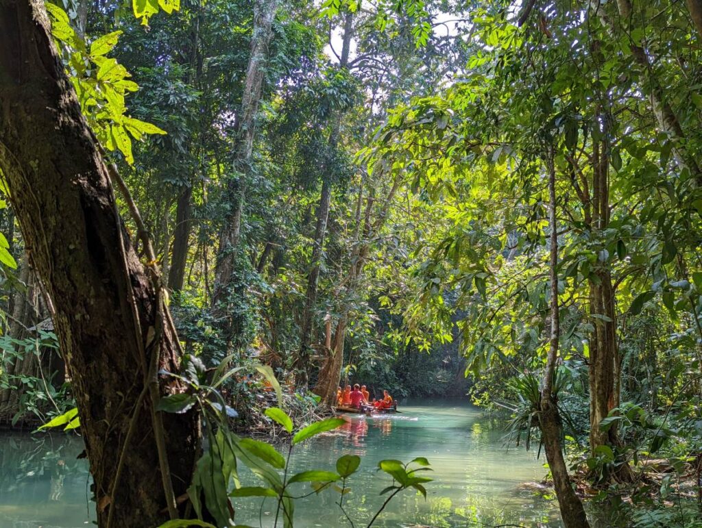 Des moines se baignent dans l'eau de Kuang Si
